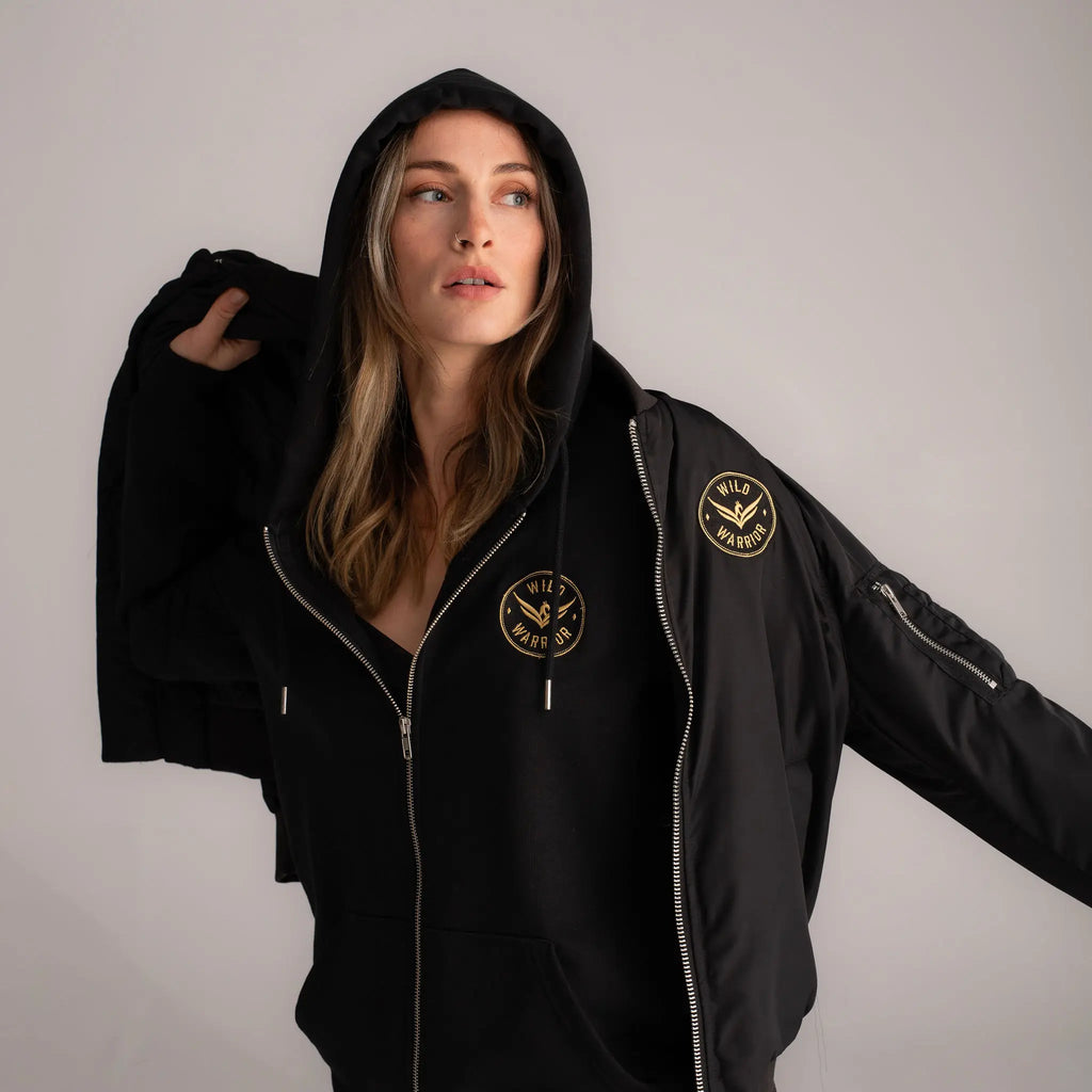 Wild Warrior woman wearing a sustainable black bomber jacket 